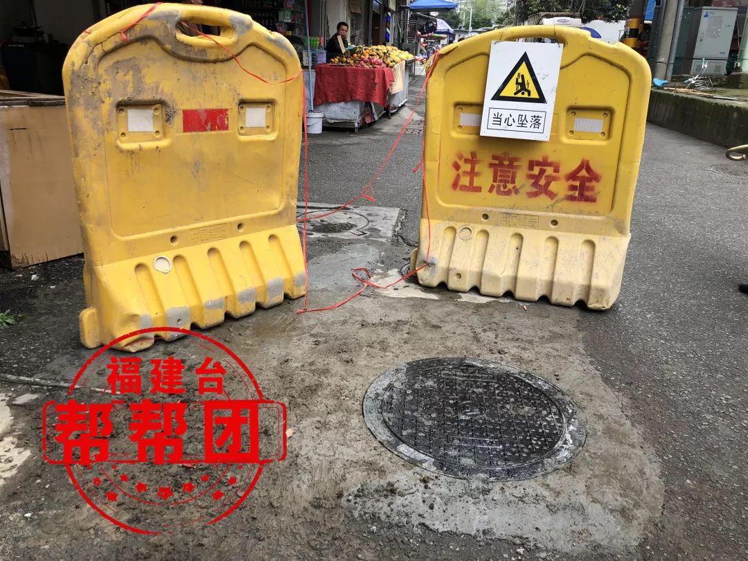 凹陷的井盖处已经修补完善了,并且在井盖旁树立了一块注意安全的警示
